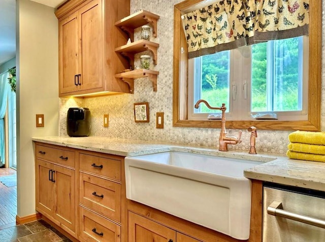 kitchen with dark hardwood / wood-style flooring, light stone counters, sink, and dishwasher