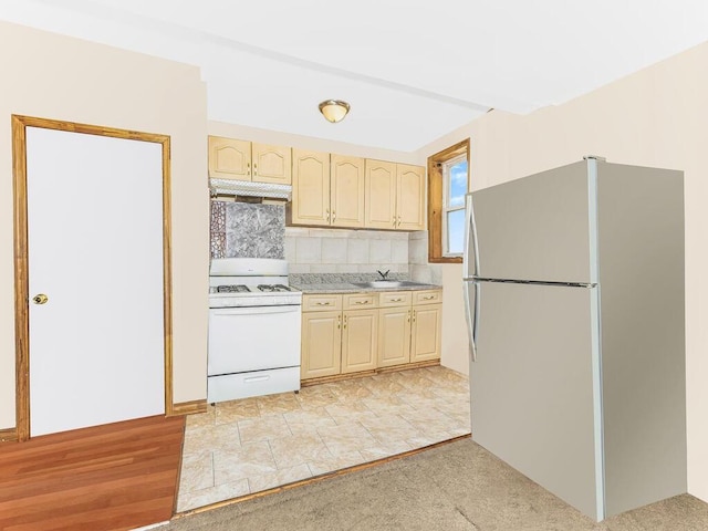 kitchen with sink, tasteful backsplash, white appliances, light brown cabinetry, and light wood-type flooring