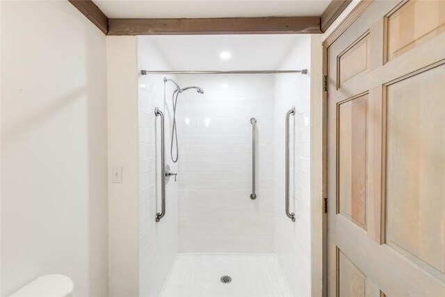 bathroom featuring toilet and tiled shower