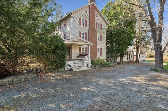 view of front facade featuring a garage, covered porch, and an outdoor structure