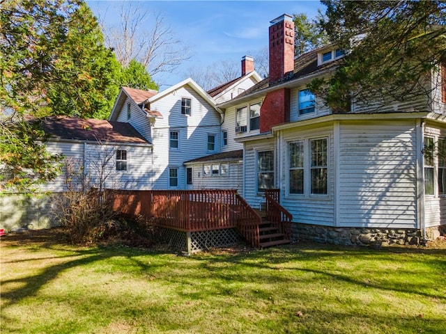 rear view of house with a lawn and a wooden deck