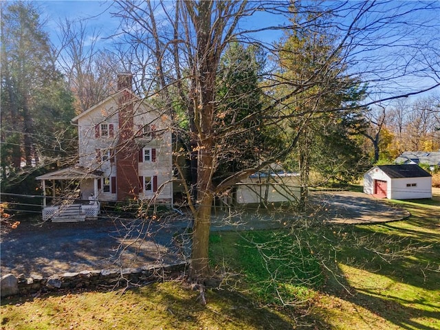 view of side of home with a yard, a garage, and an outdoor structure