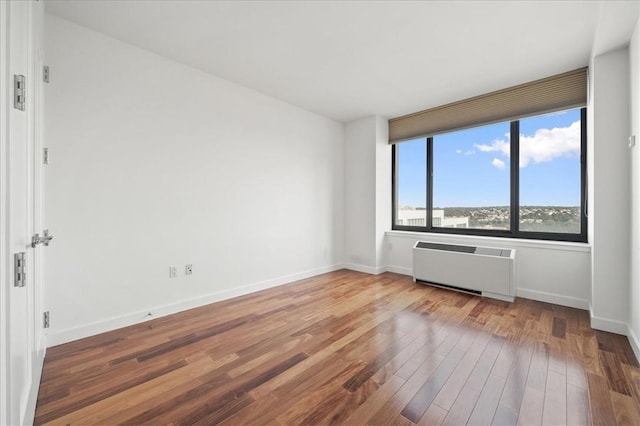 unfurnished room with radiator heating unit and wood-type flooring