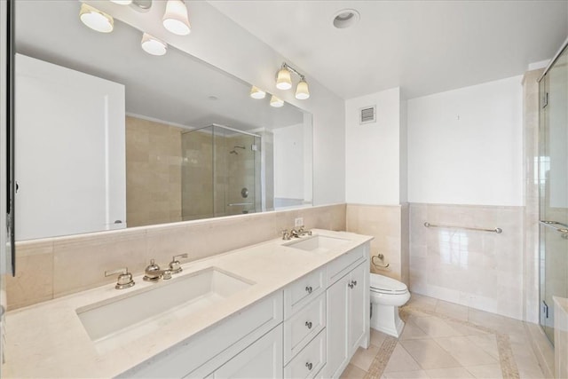 bathroom featuring walk in shower, vanity, tile walls, tile patterned flooring, and toilet