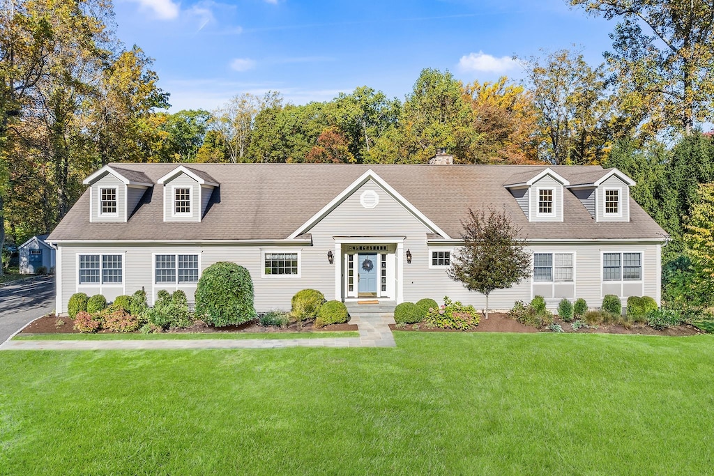 cape cod home with a front yard