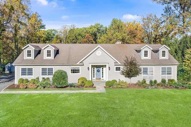 cape cod house featuring a front yard