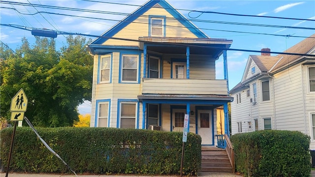 view of front of property with covered porch and a balcony