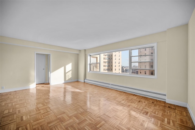 empty room with light parquet floors and a baseboard radiator