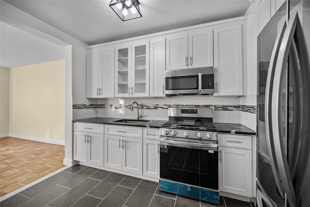 kitchen with stainless steel appliances, white cabinetry, and sink