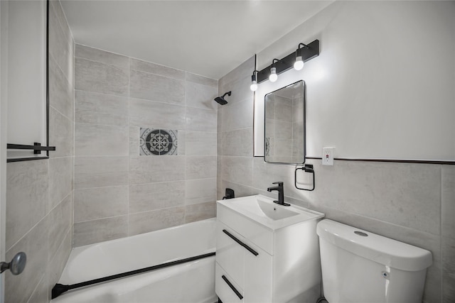 full bathroom featuring toilet, vanity, tile walls, and tiled shower / bath