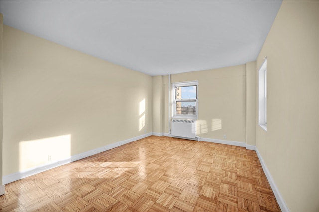 unfurnished room with radiator heating unit and light parquet flooring