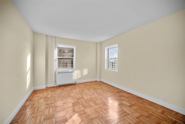 unfurnished room with radiator and light parquet flooring