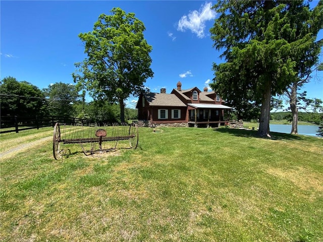 view of yard with a sunroom and a water view