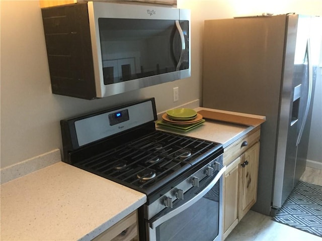 kitchen with appliances with stainless steel finishes and light brown cabinets