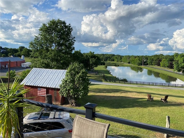 surrounding community featuring a yard, a water view, and an outbuilding