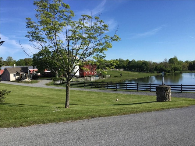 view of home's community with a yard and a water view