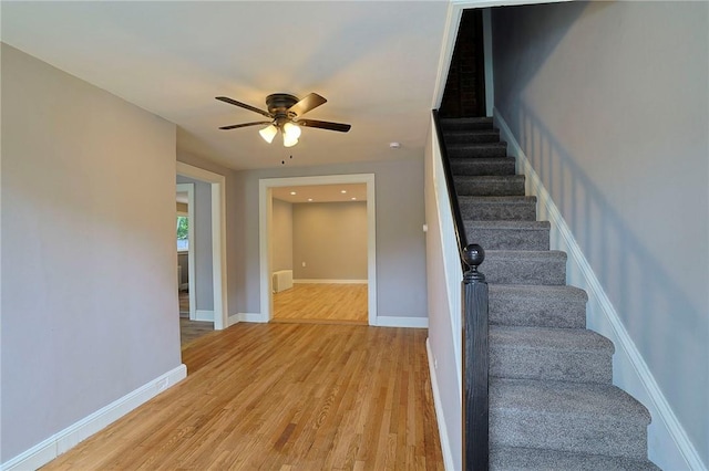 stairway featuring ceiling fan and hardwood / wood-style flooring