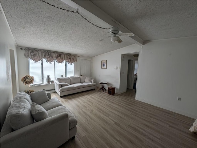 living room with lofted ceiling with beams, ceiling fan, a textured ceiling, baseboard heating, and wood-type flooring