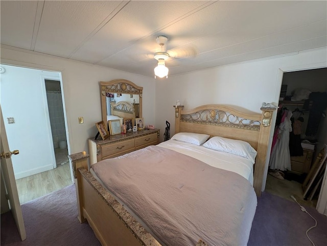 bedroom featuring ensuite bathroom, ceiling fan, and dark wood-type flooring