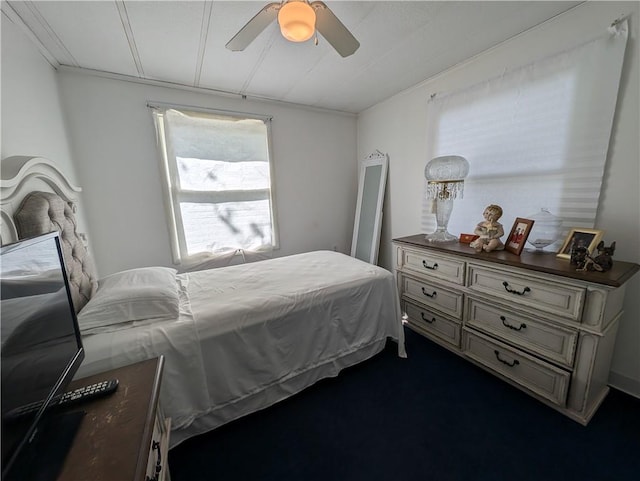 carpeted bedroom featuring ceiling fan and crown molding