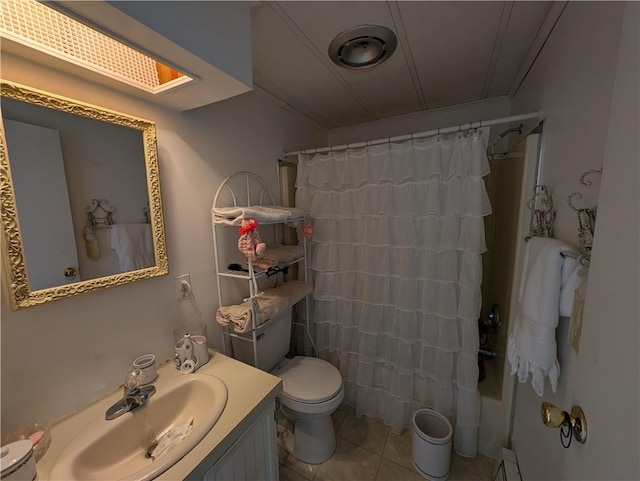 bathroom with a skylight, tile patterned floors, ornamental molding, vanity, and toilet