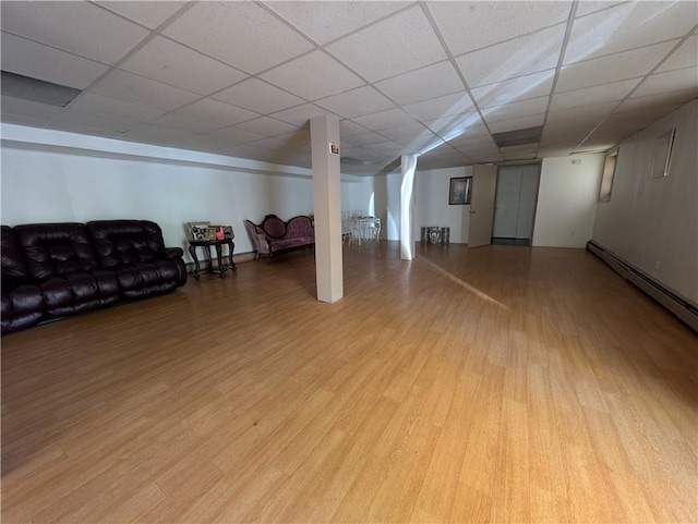 basement with light hardwood / wood-style flooring and a drop ceiling