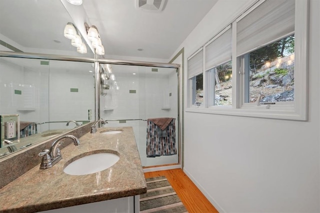 bathroom with a shower with door, plenty of natural light, and wood-type flooring