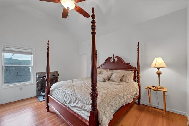 bedroom with light hardwood / wood-style floors, vaulted ceiling, and ceiling fan