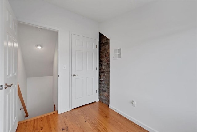 spare room featuring hardwood / wood-style flooring and lofted ceiling