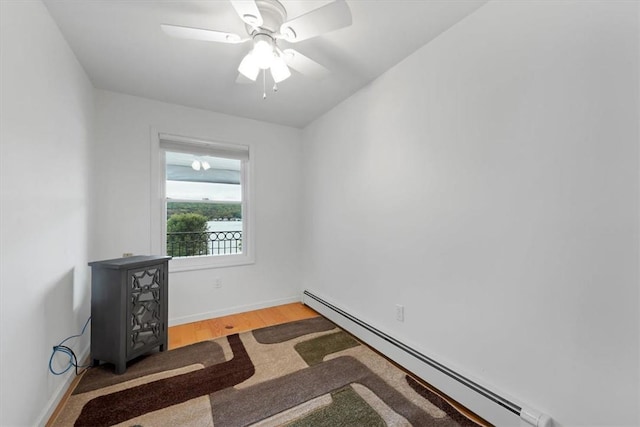 unfurnished room with baseboard heating, ceiling fan, and wood-type flooring