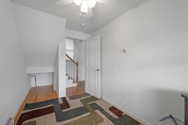 interior space with ceiling fan, a baseboard radiator, and hardwood / wood-style flooring