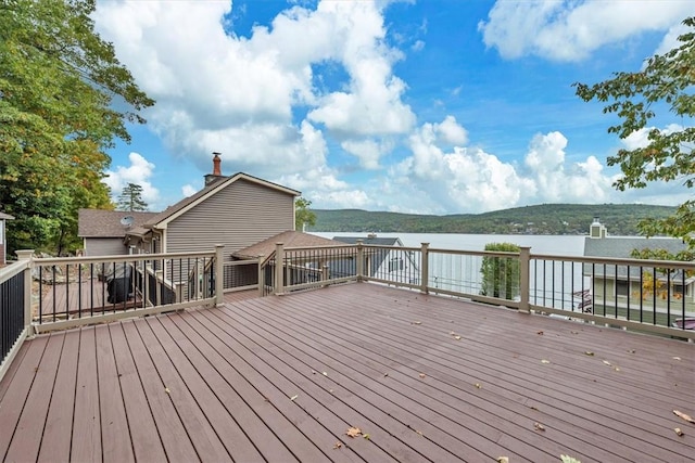 wooden terrace featuring a water and mountain view