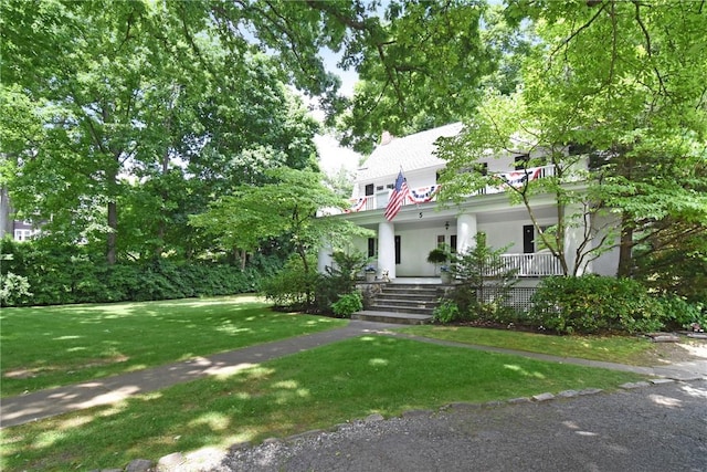 view of front of home with a porch and a front yard