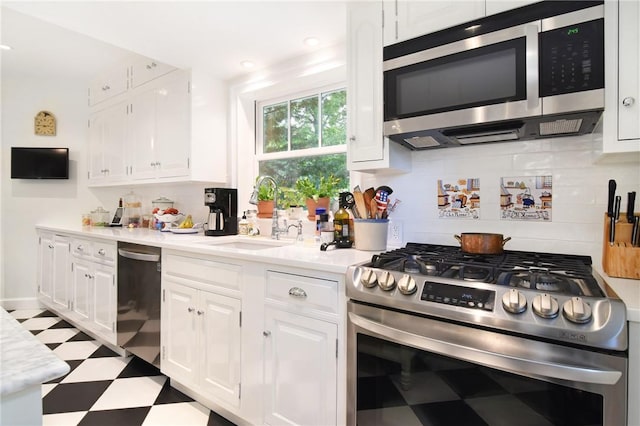 kitchen featuring tasteful backsplash, white cabinetry, sink, and appliances with stainless steel finishes