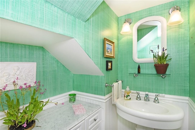 bathroom featuring sink and lofted ceiling