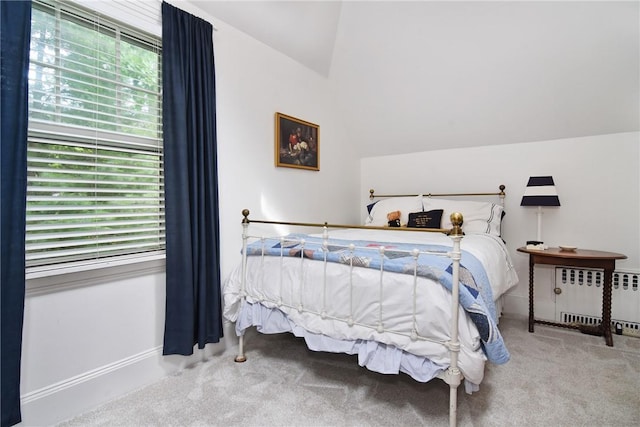 carpeted bedroom with radiator and lofted ceiling