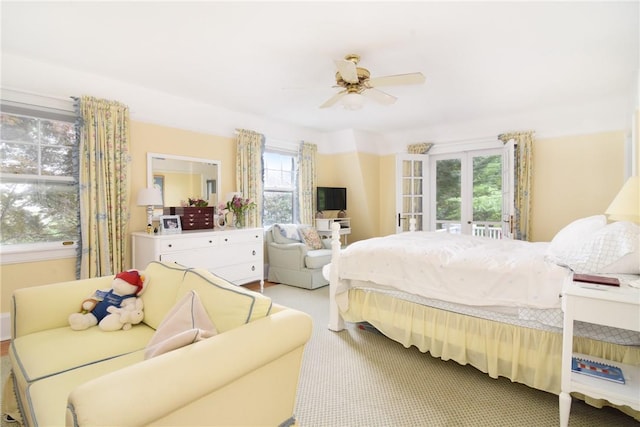 carpeted bedroom featuring french doors, multiple windows, and ceiling fan