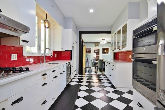 kitchen featuring white cabinets, extractor fan, stainless steel dishwasher, and sink