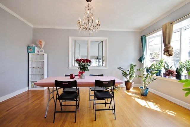 dining space with a chandelier, light wood-type flooring, and ornamental molding