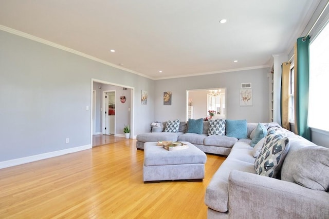 living room featuring a notable chandelier, light hardwood / wood-style floors, and ornamental molding