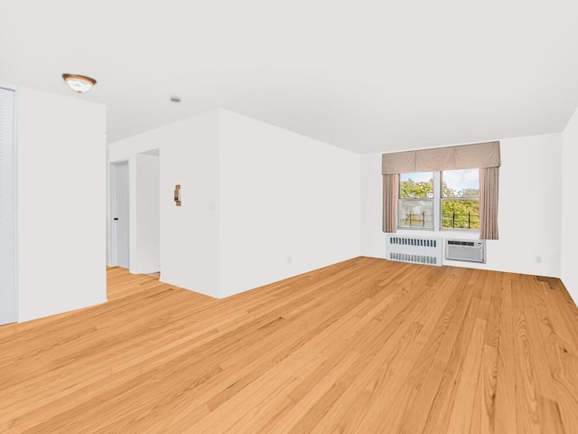 unfurnished living room featuring a wall mounted air conditioner, radiator heating unit, and light wood-type flooring