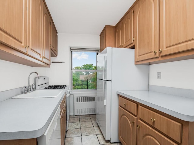 kitchen featuring light tile patterned flooring, white appliances, sink, and radiator