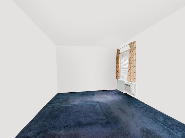 unfurnished room featuring dark carpet