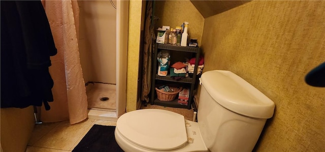 bathroom featuring tile patterned flooring, toilet, and walk in shower