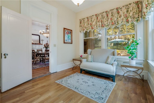 sitting room with hardwood / wood-style flooring and a chandelier