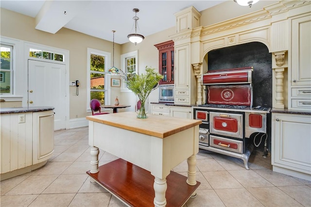 kitchen featuring cream cabinetry, decorative light fixtures, a kitchen island, and plenty of natural light