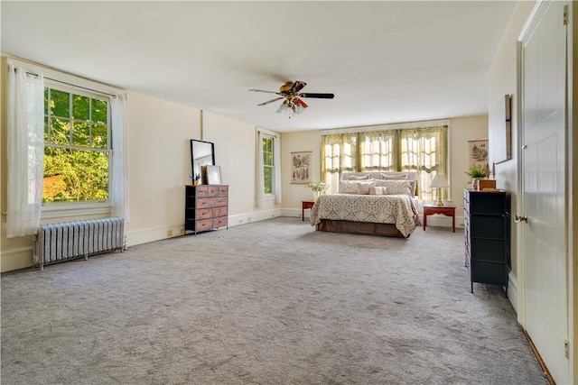 unfurnished bedroom featuring light carpet, radiator heating unit, and ceiling fan