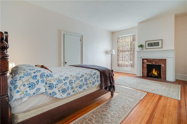 bedroom featuring a fireplace and wood-type flooring