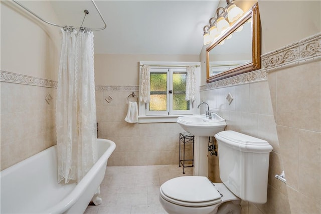 full bathroom featuring shower / bath combination with curtain, tile patterned floors, sink, tile walls, and toilet