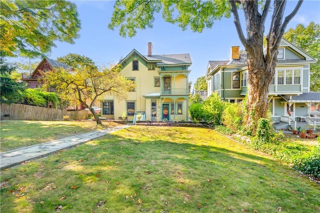 view of front of property with a balcony and a front lawn